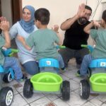 Evlerini evlat edinilmiş bir aile olan üçüzlerle alkışladılar
